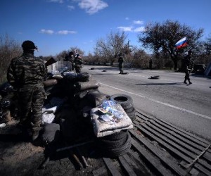 Serbian and Cossack armed men work with Pro-Russian forces as they stand guard at a checkpoint on the road from Simferopol to Sevastopol on March 13, 2014 (AFP, Filippo Monteforte)