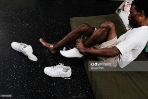 > on December 7, 2017 in St JoDanny Jeffrey, A displaced resident from the island of Barbuda, puts on his shoes inside a shelter at a cricket stadium on December 7, 2017 in St John's, Antiqua.hn's, [COUNTRY].