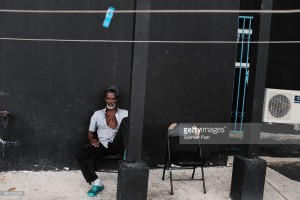 A displaced resident from the island of Barbuda sits inside a shelter at a cricket stadium on December 7, 2017 in St John's, Antiqua. Barbuda