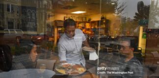 Ethiopian restaurant workers serve customers in Washington, D.C., highlighting the everyday lives of Ethiopian immigrants affected by the termination of TPS.