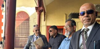 Azruddin Mohamed stands with his lawyers outside the Georgetown Magistrates’ Court during his ongoing US extradition proceedings.
