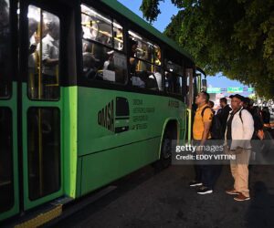 Passengers wait to board an overcrowded bus during a nationwide blackout in the Dominican Republic, causing major transportation disruptions.