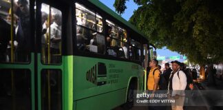 Passengers wait to board an overcrowded bus during a nationwide blackout in the Dominican Republic, causing major transportation disruptions.