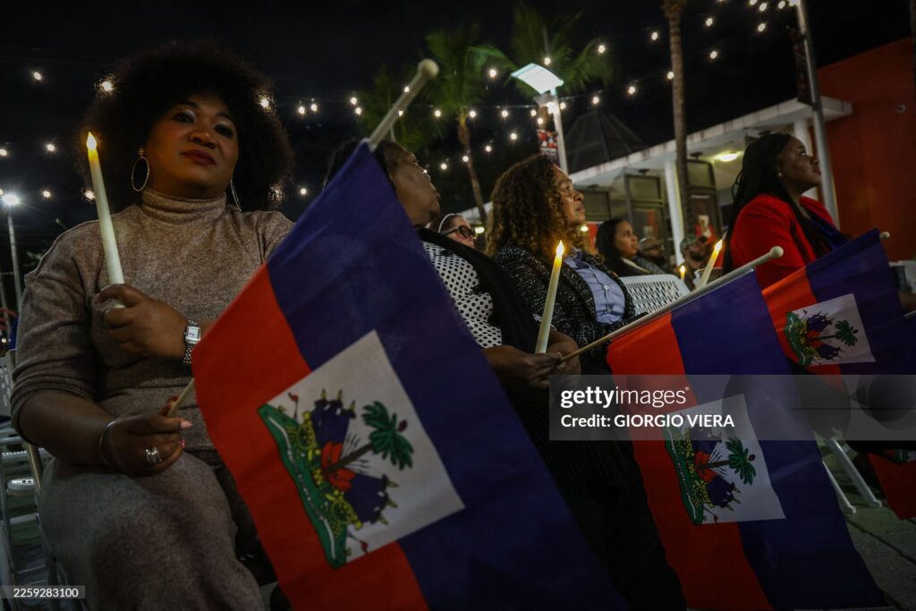 People attend a candlelight vigil for Haitians living in the US under the Temporary Protected Status (TPS) immigration program in Miami, Florida on February 3, 2026. Late on February 2, federal judge Ana C. Reyes of the Federal District Court in Washington, blocked the Trump administration from ending TPS for an estimated 350,000 Haitian immigrants. The status, which offers protection from deportation and work authorization, was set to expire on Feb. 3. 2026