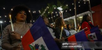 People attend a candlelight vigil for Haitians living in the US under the Temporary Protected Status (TPS) immigration program in Miami, Florida on February 3, 2026. Late on February 2, federal judge Ana C. Reyes of the Federal District Court in Washington, blocked the Trump administration from ending TPS for an estimated 350,000 Haitian immigrants. The status, which offers protection from deportation and work authorization, was set to expire on Feb. 3. 2026
