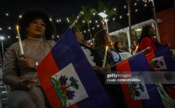 People attend a candlelight vigil for Haitians living in the US under the Temporary Protected Status (TPS) immigration program in Miami, Florida on February 3, 2026. Late on February 2, federal judge Ana C. Reyes of the Federal District Court in Washington, blocked the Trump administration from ending TPS for an estimated 350,000 Haitian immigrants. The status, which offers protection from deportation and work authorization, was set to expire on Feb. 3. 2026