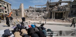 A group of Iranian men prays in an area that is targeted in U.S.-Israeli attacks in Tehran, Iran, on March 4, 2026.