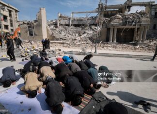 A group of Iranian men prays in an area that is targeted in U.S.-Israeli attacks in Tehran, Iran, on March 4, 2026.