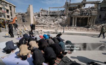 A group of Iranian men prays in an area that is targeted in U.S.-Israeli attacks in Tehran, Iran, on March 4, 2026.